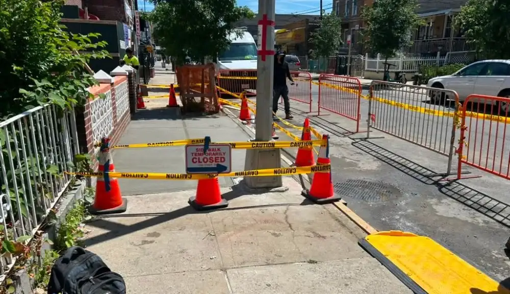 sidewalk repair work zone with caution barriers and temporary walkway closure at 2712 holland avenue in the Bronx